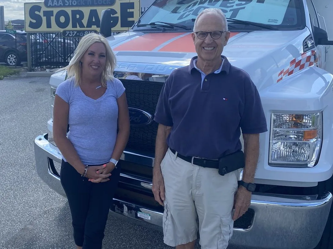 The AAA Stock 'n Lock family owners in front of the Windsor facility and a U-Haul truck