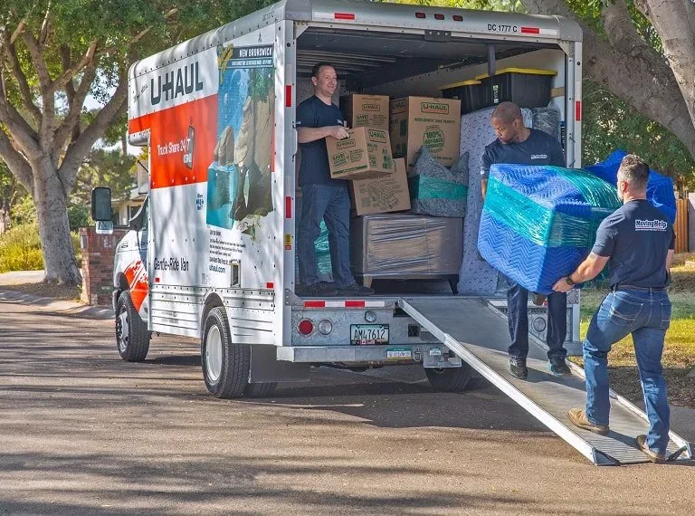 Movers loading boxes into a U-Haul truck at the storage facility